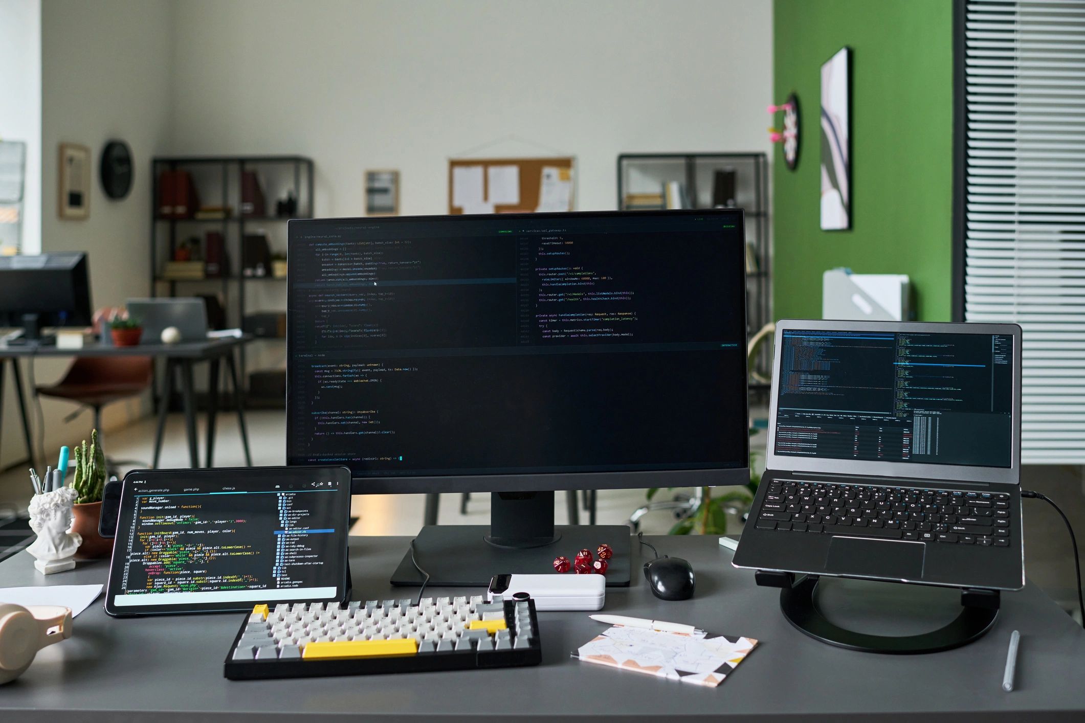 Software development workspace with laptop, monitor, and code display